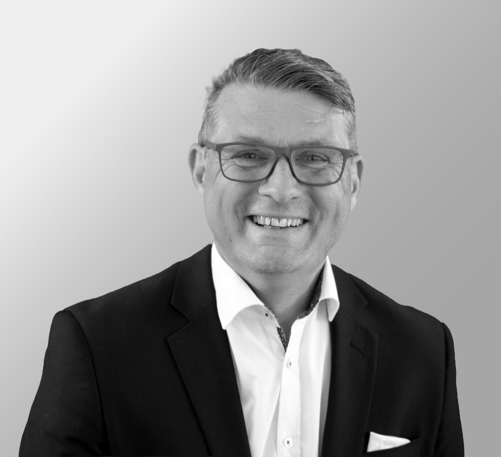 Jan Brandstein lächelt, in dunklem Sakko und mit Brille